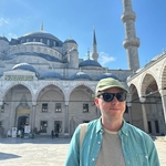 Calum in a green shirt and sunglasses with the backdrop of Blue Mosque, Istanbul
