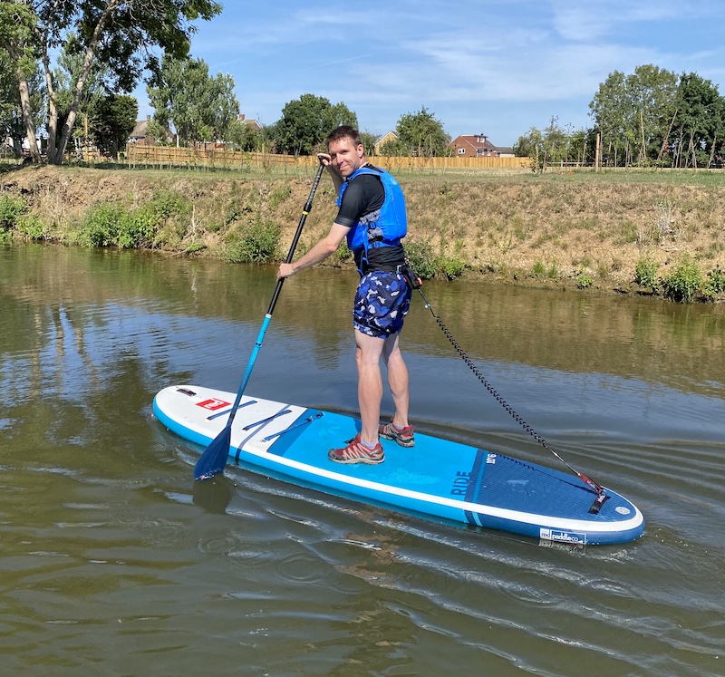 Calum standing on a paddleboard on the River Medway