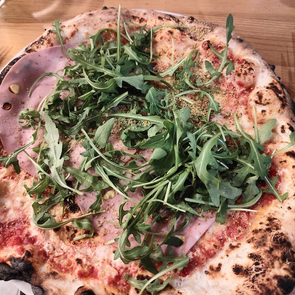 Close up of pizza with rocket leaves on top