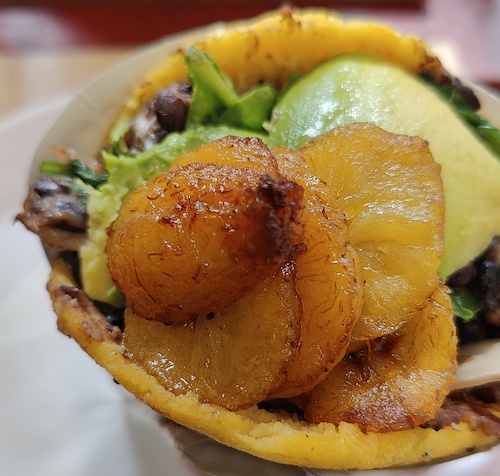 close up of arepa with beans and avocado