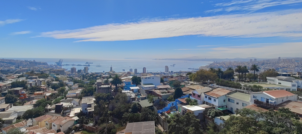 Panorama of Valparaíso overlooking coloured rooftops and sea in backdrop with clear blue sky