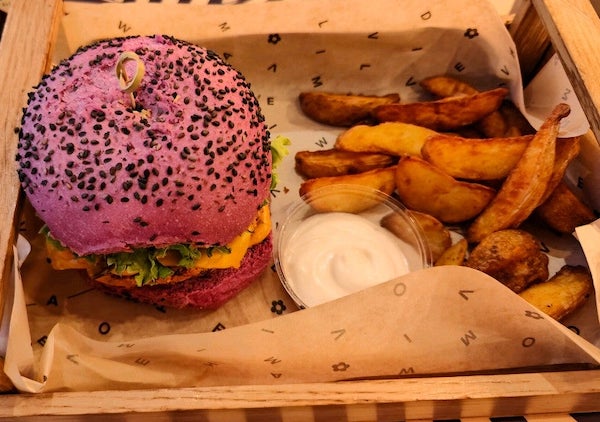 Pink coloured burger and potato wedges