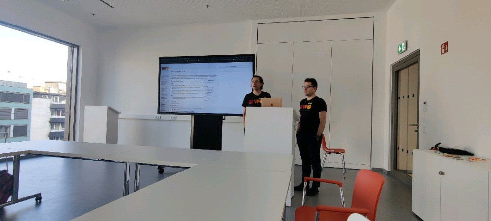 Tantek and Aaron beside a large screen