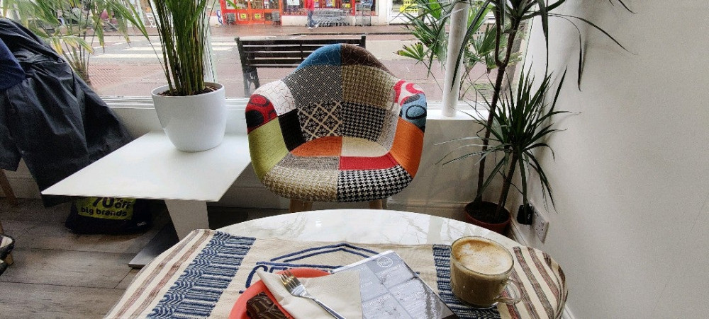 Coffeeshop table with multi-coloured chair and window backdrop