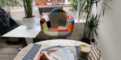 Coffeeshop table with multi-coloured chair and window backdrop