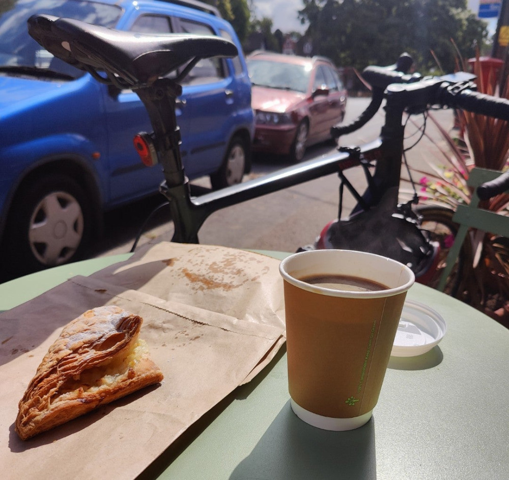 coffee and apple turnover in outdoor table next to a bicycle