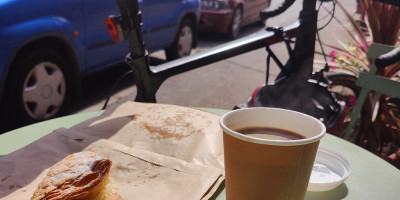 coffee and apple turnover in outdoor table next to a bicycle