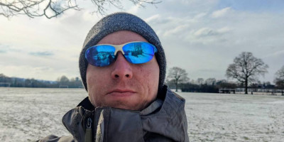 Calum wearing blue sun glasses at a snow-covered field in Tonbridge