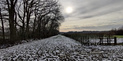 Bridle path near Tonbridge with melting snow and sun peaking through clouds