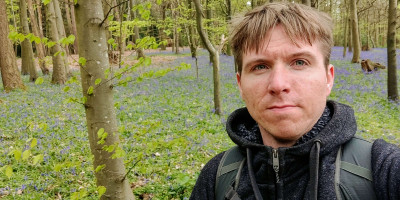 Calum with backdrop of bluebell covered forest
