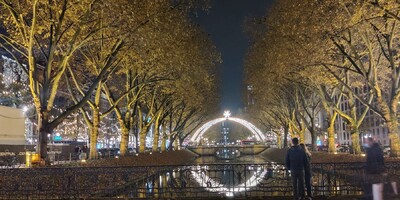 Night shot of Düsseldorf river and Christmas arc of lights with star