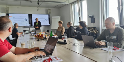 Seven attendees at IndieWebCamp inside a large conference room at CGI Düsseldorf