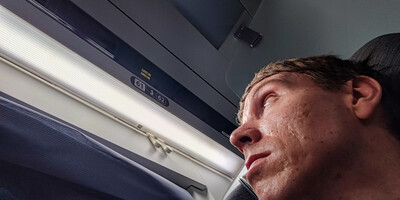 Calum looking above his train seat at number 61