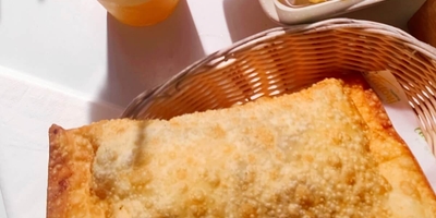 Pastel de carne, a plate of Yuca fried with a plastic galss of passion fruit juice