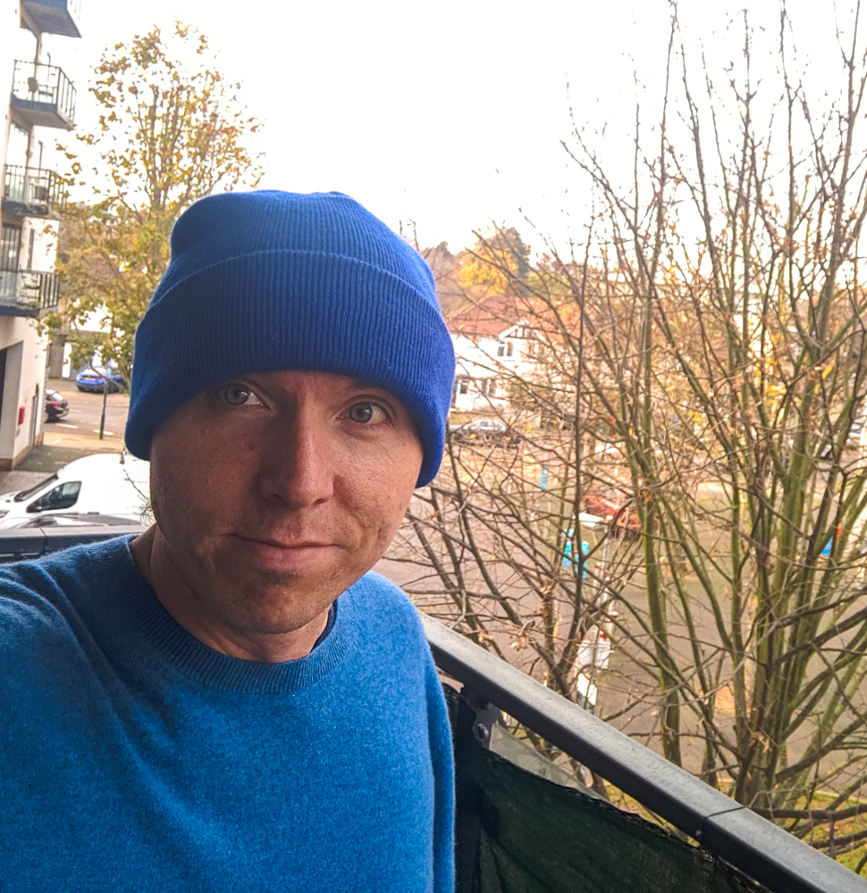 It's me wearing a blue beanie and blue jumper with the backdrop of the balcony