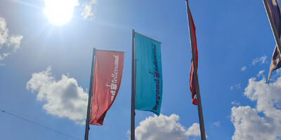 Beyond Tellerrand flags to the backdrop of a clear blue sky and flaring sunshine